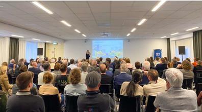 Deelnemers luisteren naar een presentatie