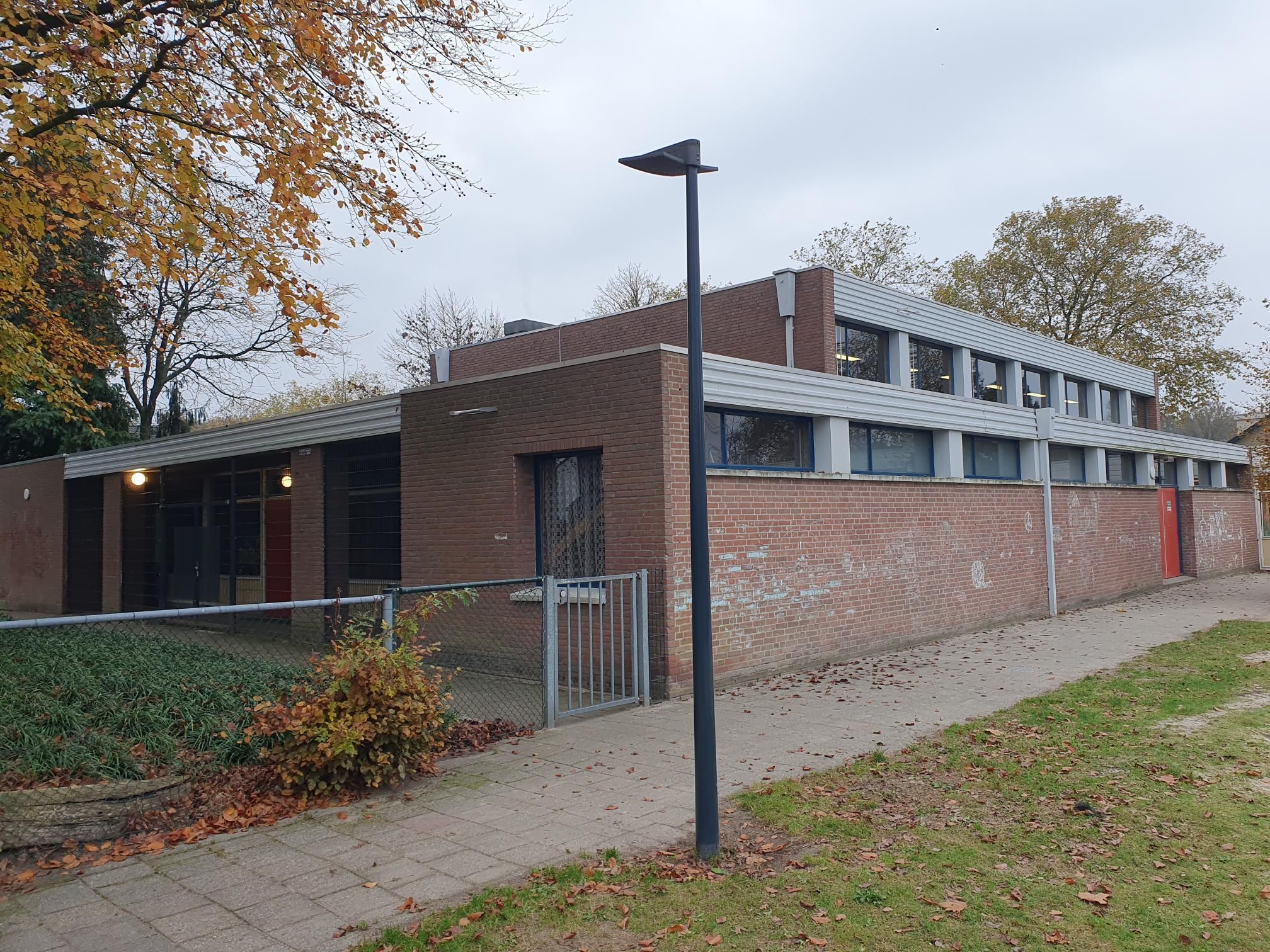 bakstenen gebouw met pad, gras en lantaarnpaal