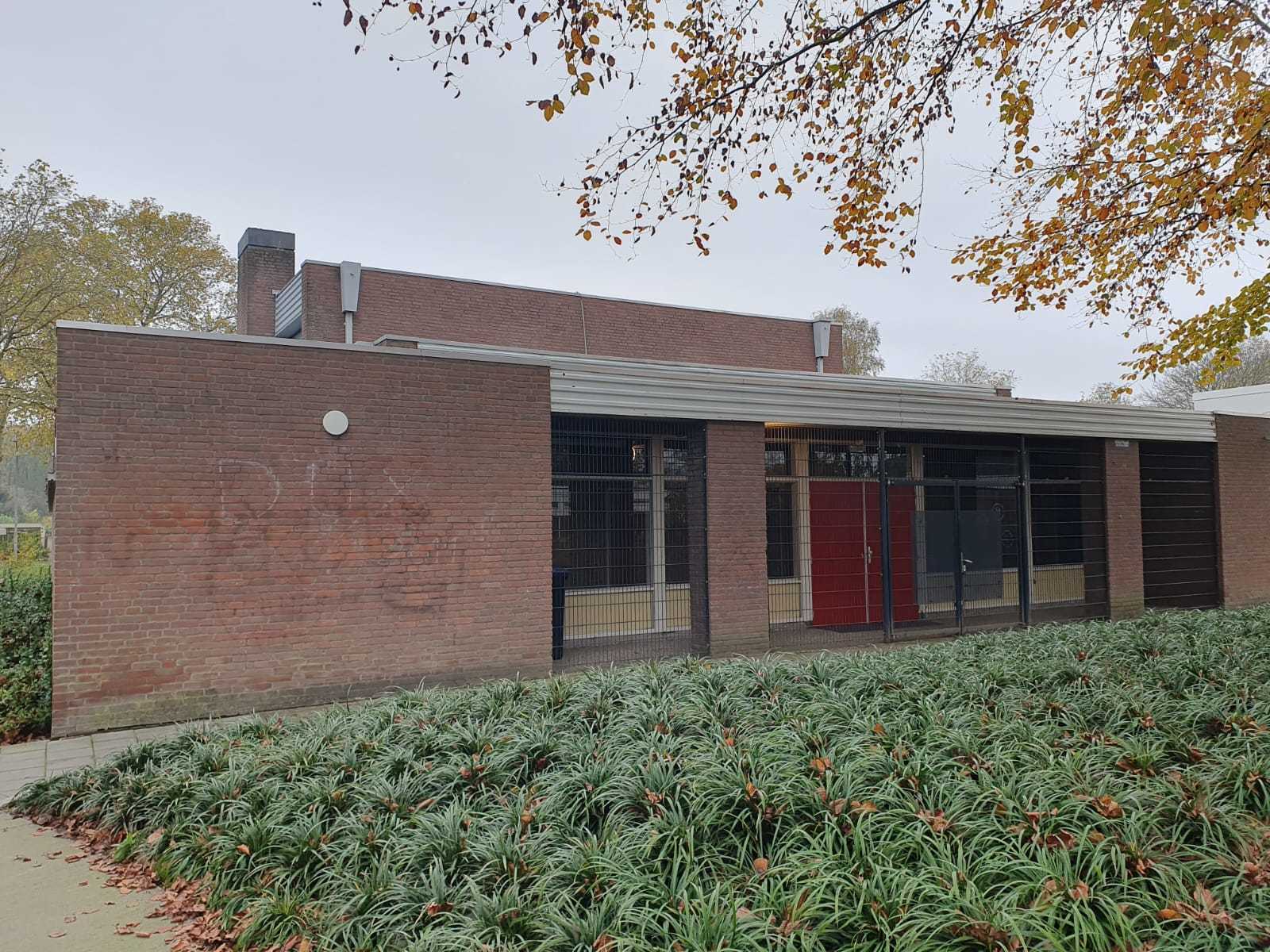 bakstenengebouw met planten voor ingang