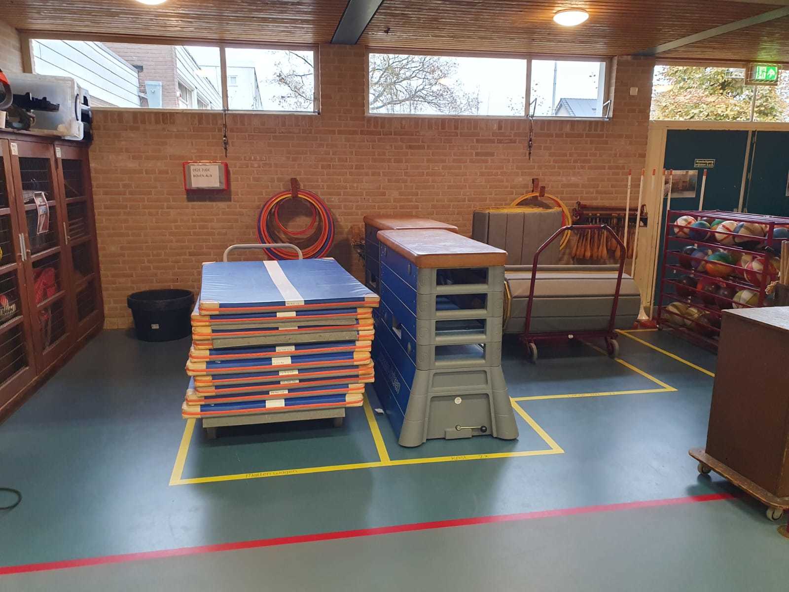 gymmaterialen, zoals matten op een kar en een bok