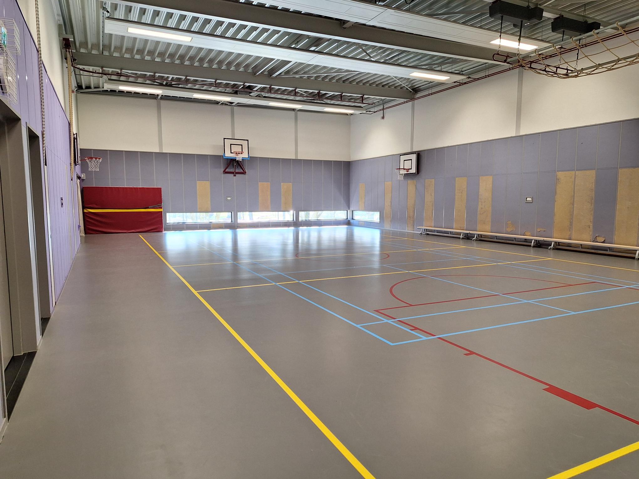 gymzaal met grijze vloer en metalen plafond