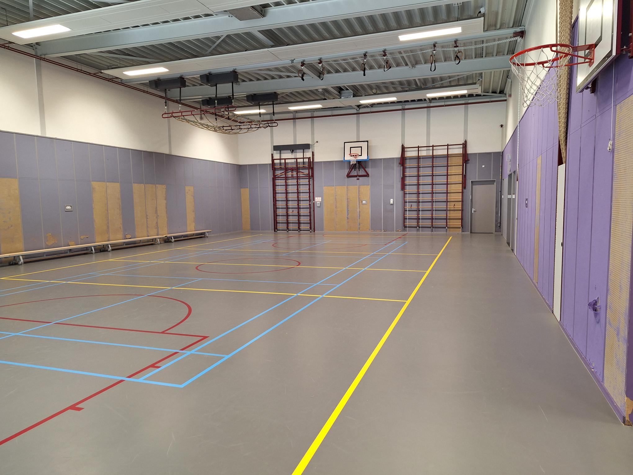 gymzaal met grijze vloer en metalen plafond