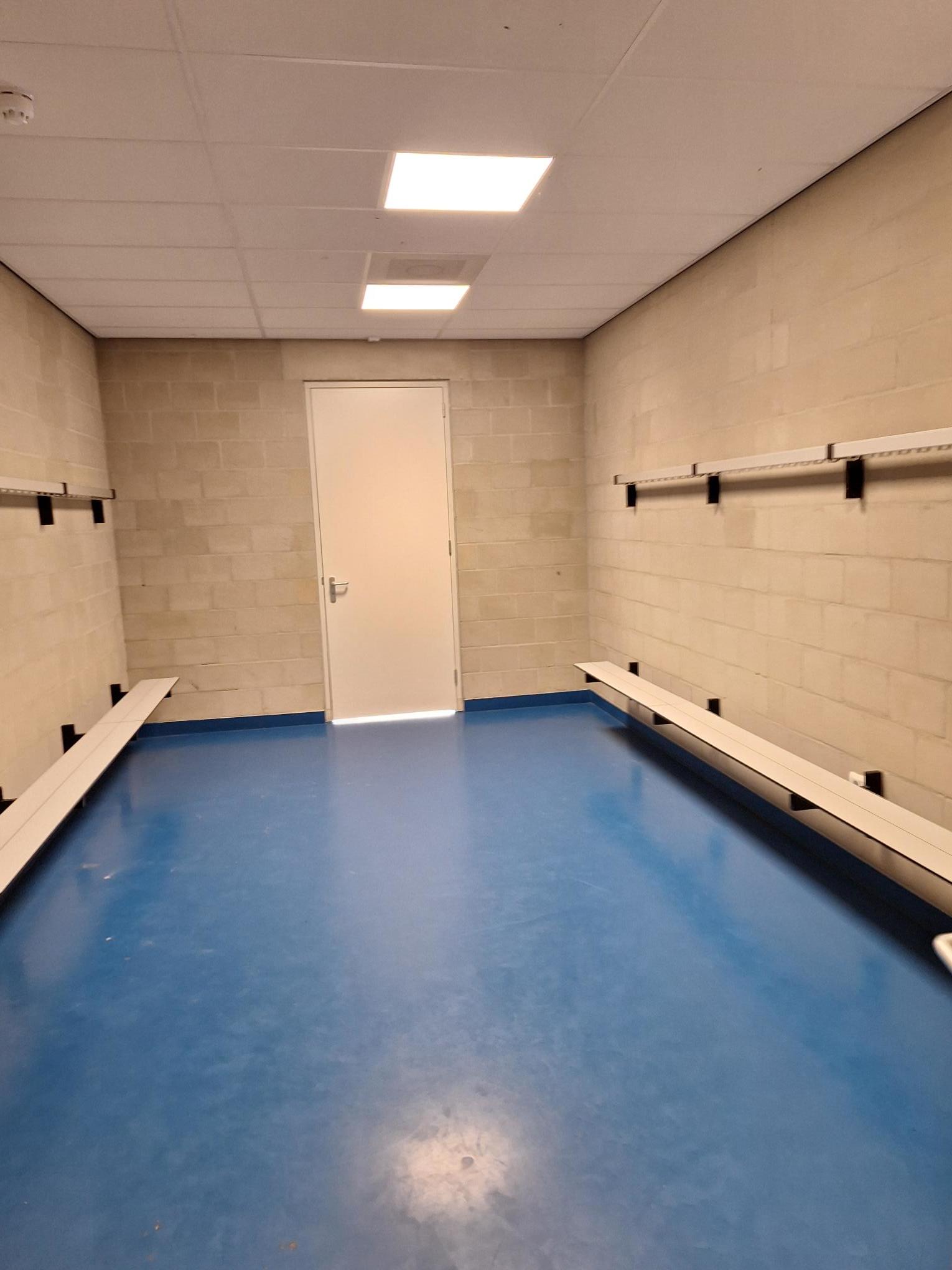 kleedkamer met stenen muren en blauwe vloer