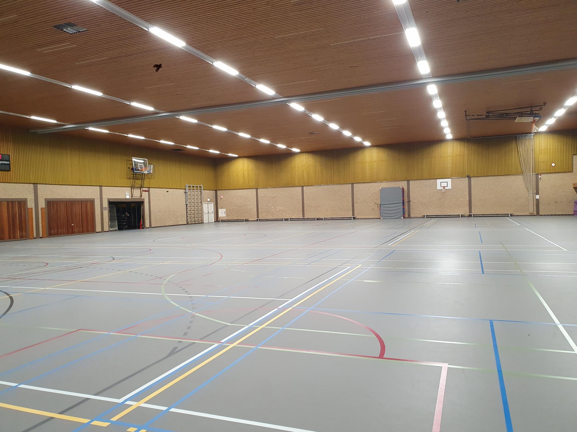 grijze gymzaal met houten plafond