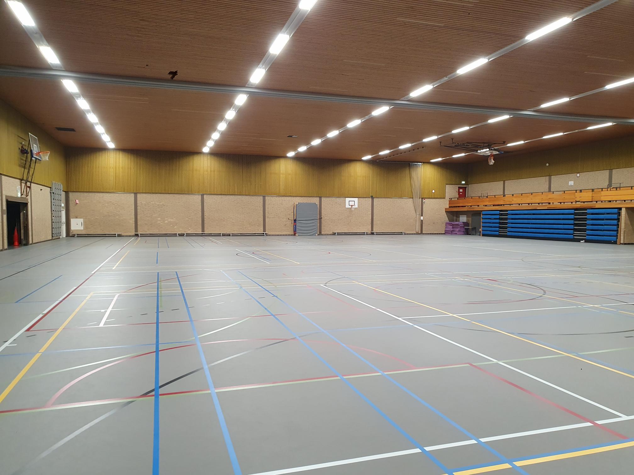 grijze gymzaal met houten plafond