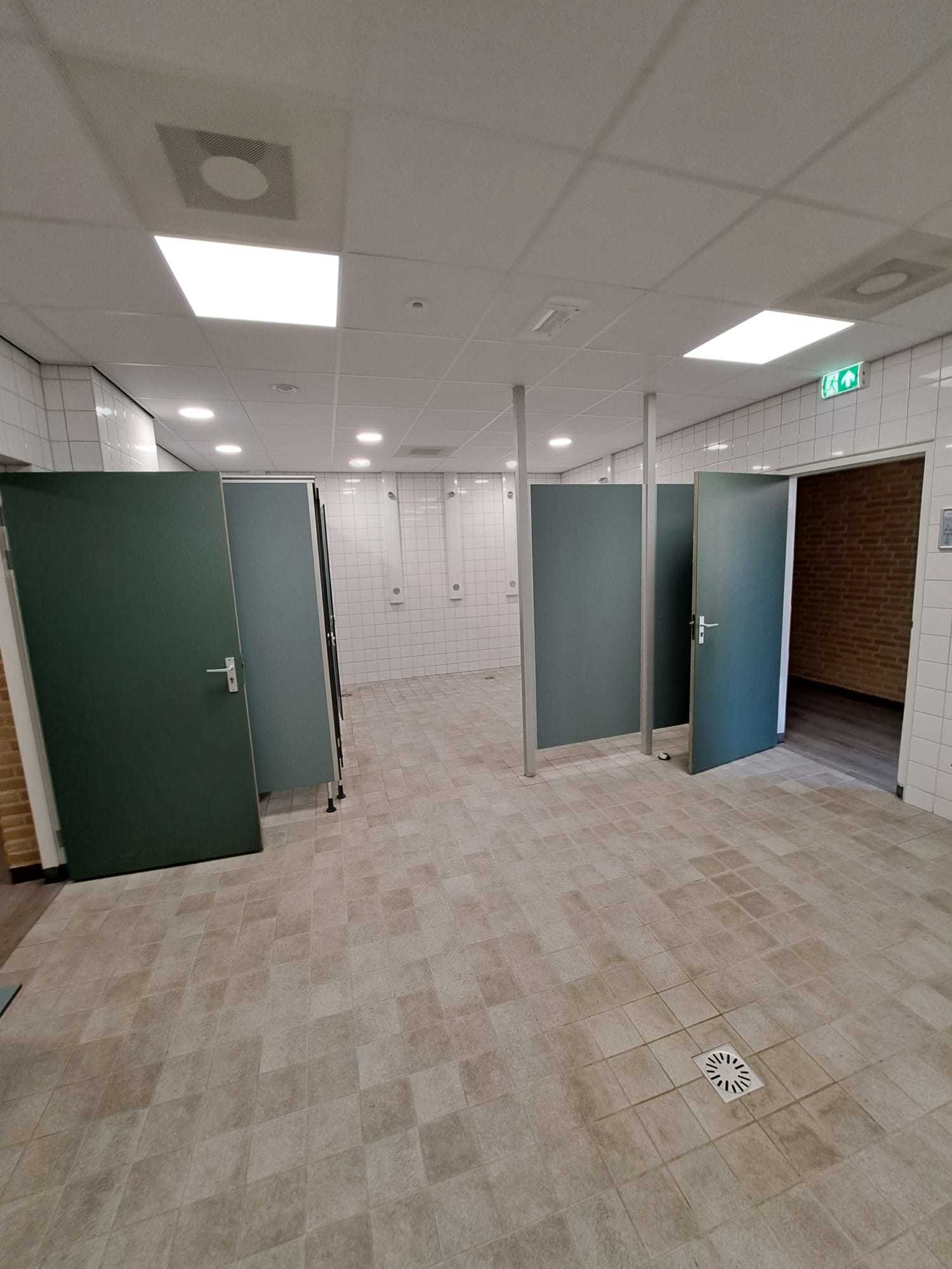 betegelde ruimte met aparte kleedhokjes en systeemplafond