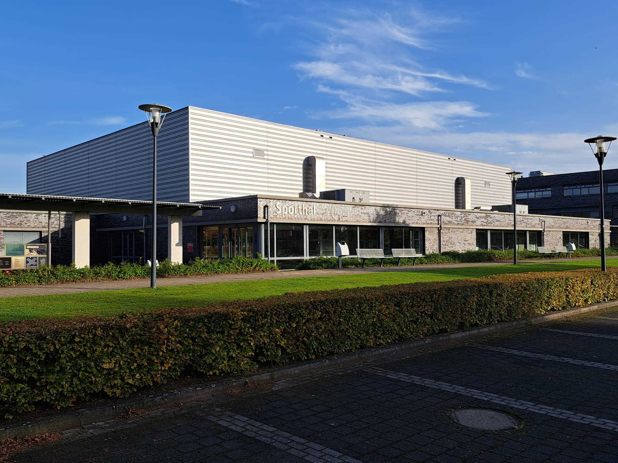 hoekig sportgebouw voorzijde met blauwe lucht