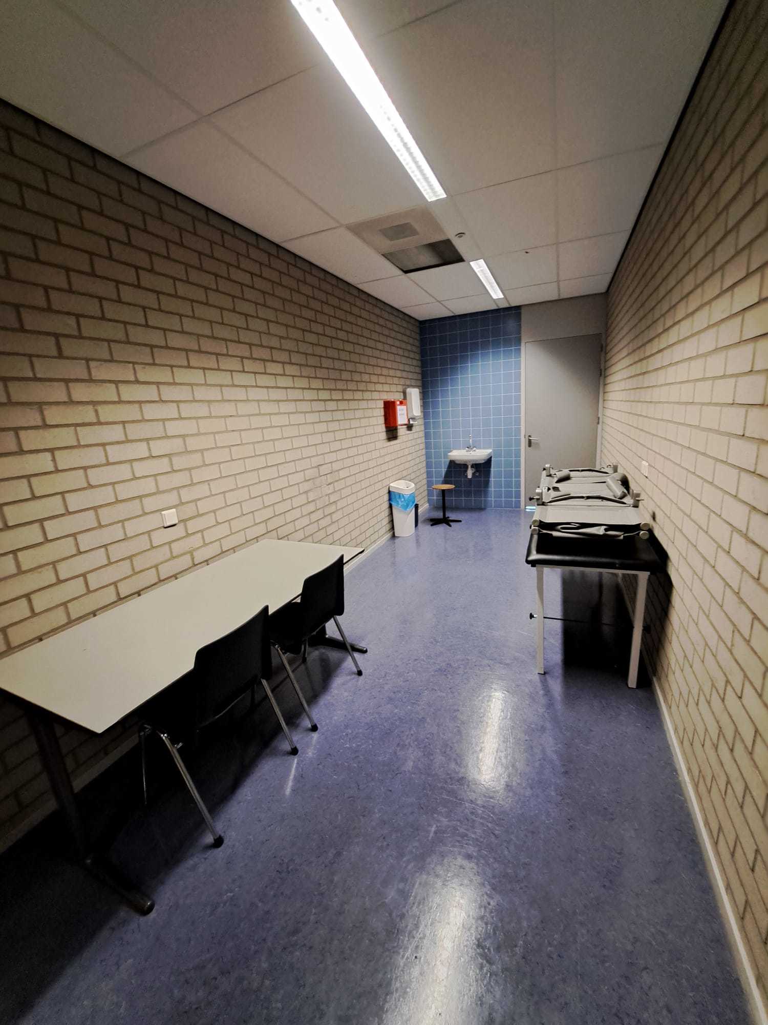 kleine ruimte met stenen muren en massagetafel