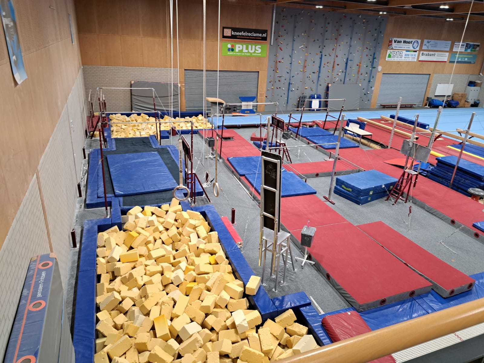 grote zaal met dikke rode matten op de vloer en schuimblokken