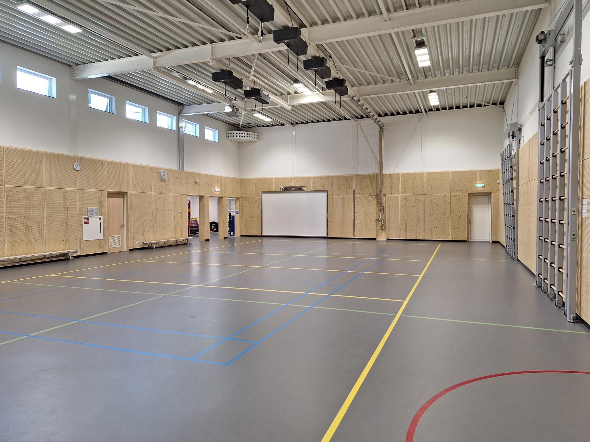 gymzaal met grijze vloer en metalen plafond