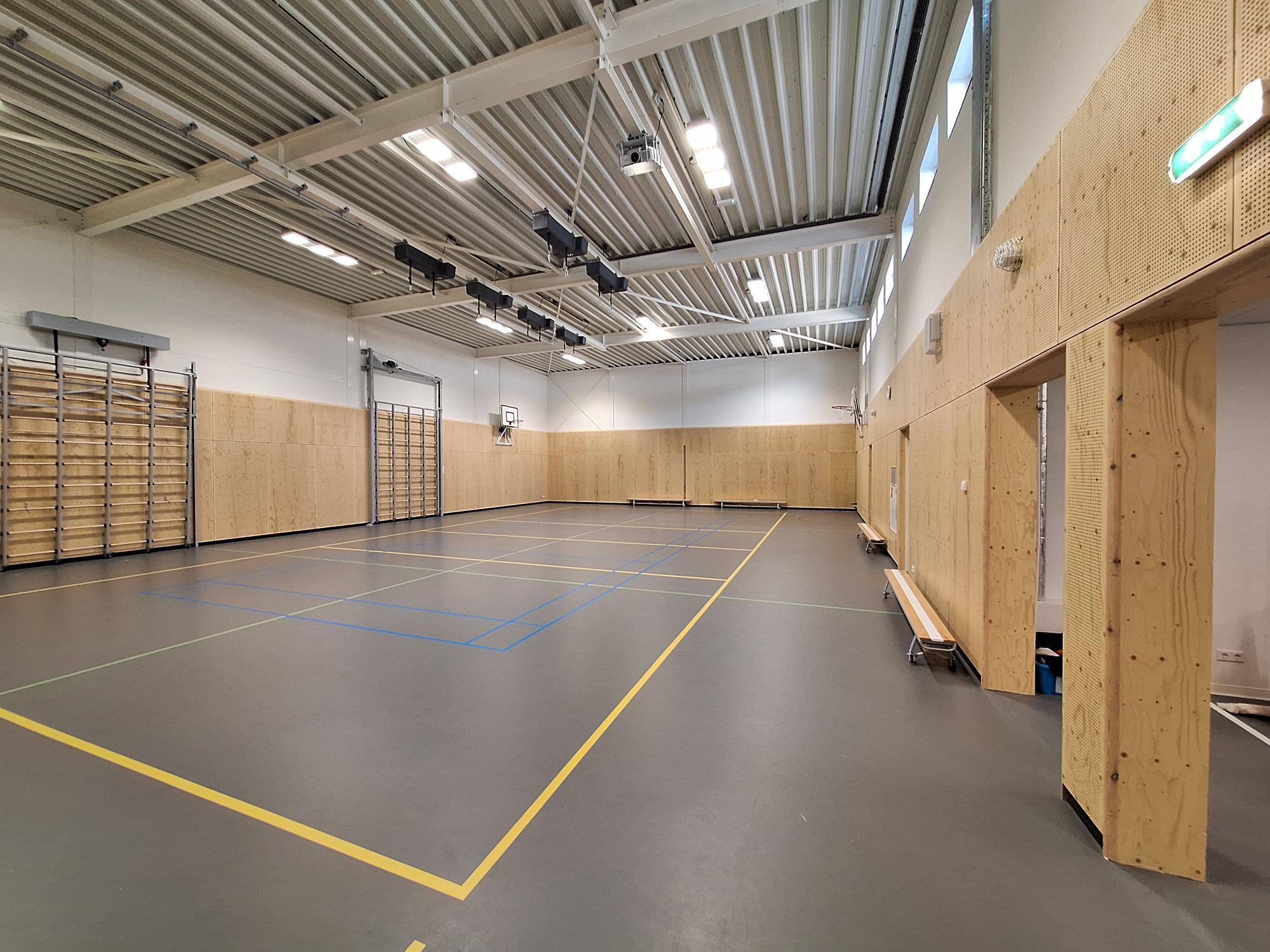 gymzaal met grijze vloer en metalen plafond