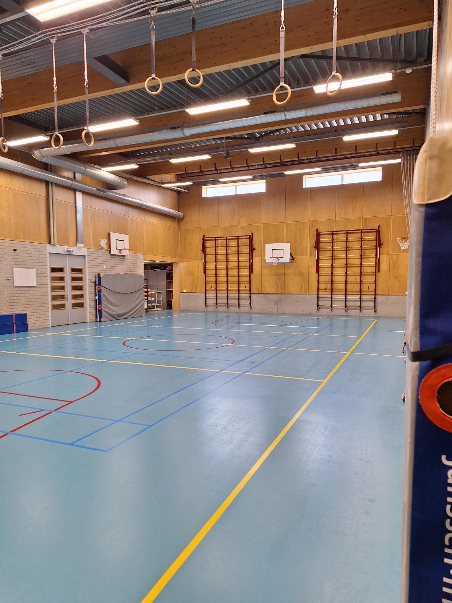 gymzaal met lichtblauwe voer en houten muren