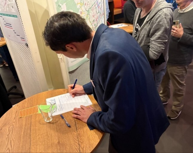 Meneer is aan het schrijven tijdens de participatiebijeenkomst op 16 april 2025