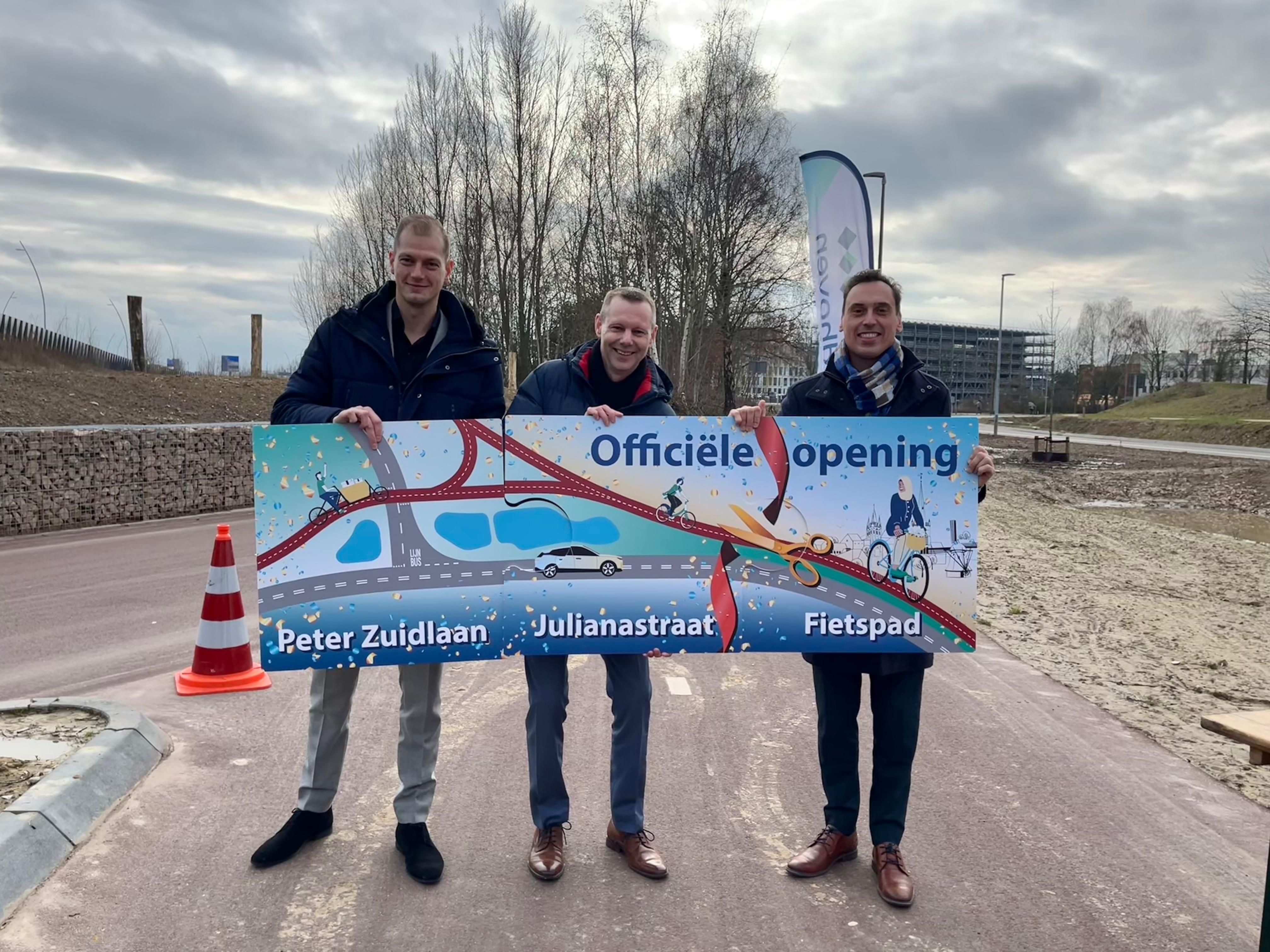 De Provincie Brabant, KWS Infra en de gemeente Veldhoven houden drie puzzelstukken vast als symbool voor de verbinding van de Peter Zuidlaan met de Julianastraat